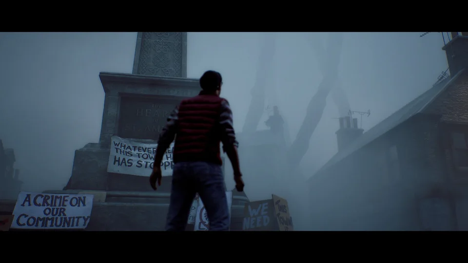 A man in a striped shirt stands by a monument and protest placards in a foggy square