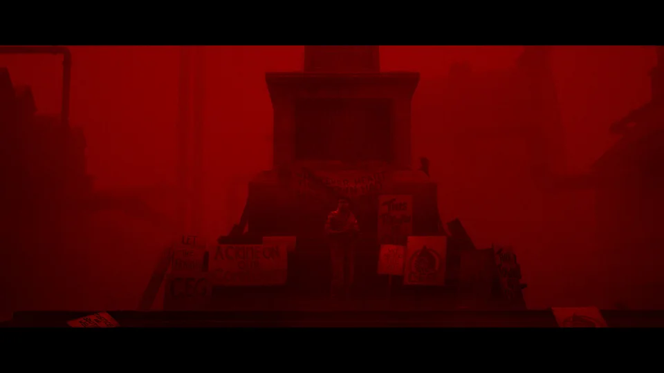 A stone monument and surrounding buildings seen through red fog