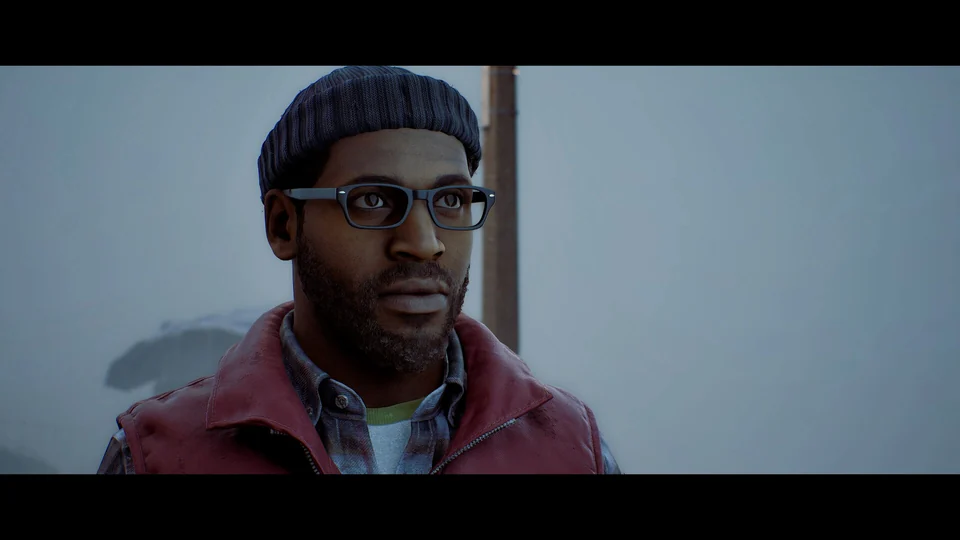 A man wearing glasses, a knitted cap and a red padded vest on a foggy shore