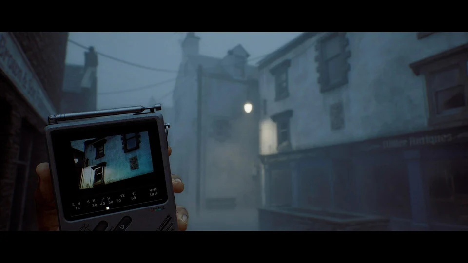 A handheld CRTV in front of foggy buildings and a street corner